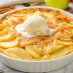 A baked apple crisp topped with a scoop of vanilla ice cream.