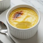 A small white ramekin holds a creamy, light yellow custard with a slightly browned top.