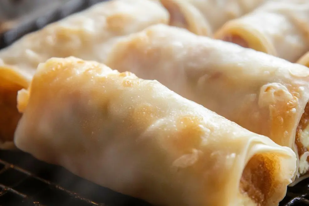The first step of frying egg rolls, an example for the Why Are My Egg Rolls Not Crispy? Restaurant Secrets Exposed.
